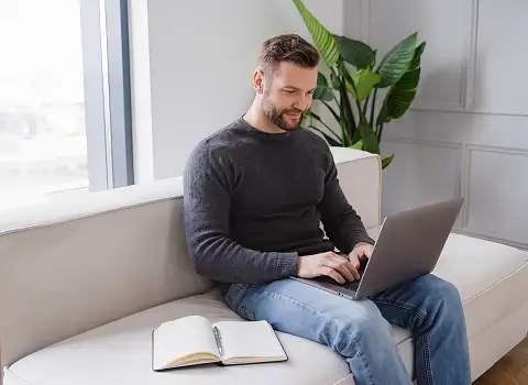 Person plant Langzeiturlaub am Laptop