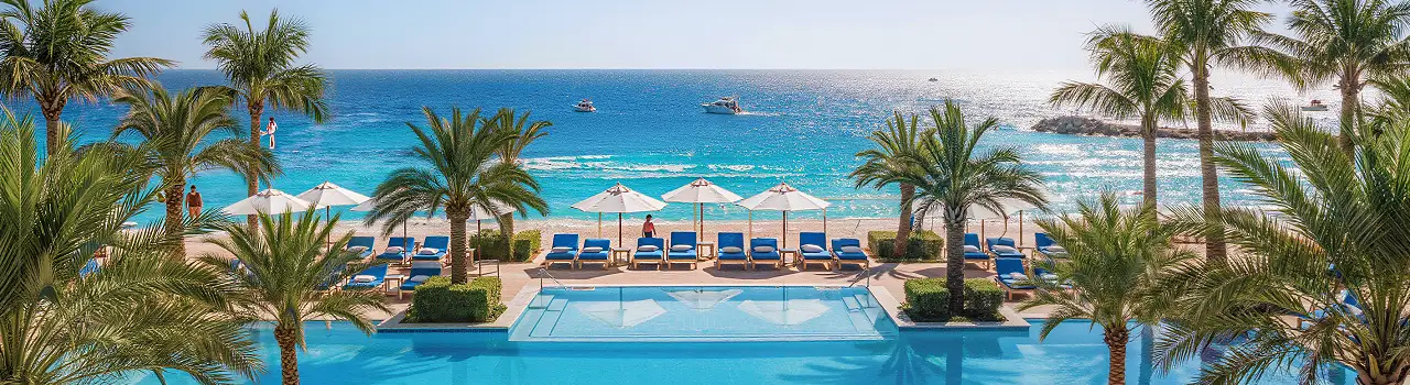 All inclusive Resort in Djerba mit Pool, Palmen und Meerblick, Sonnenliegen und blauem Himmel.