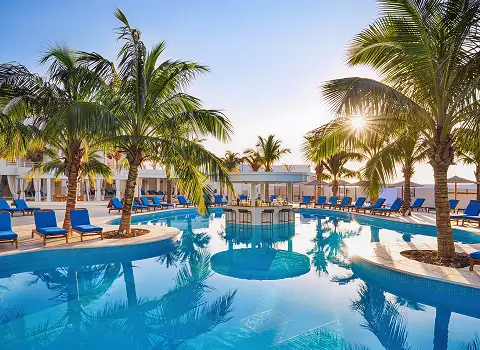 Pool mit Palmen und Liegen in einem All Inclusive Resort Hammamet