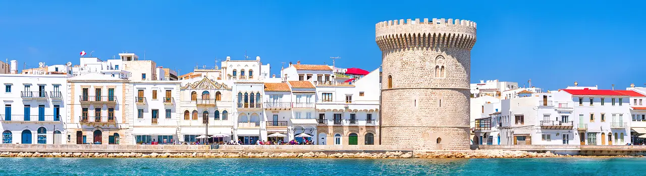 Panorama der K&uuml;stenstadt Sousse in Tunesien mit historischer Festung, wei&szlig;en Geb&auml;uden und t&uuml;rkisblauem Meer unter klarem Himmel.